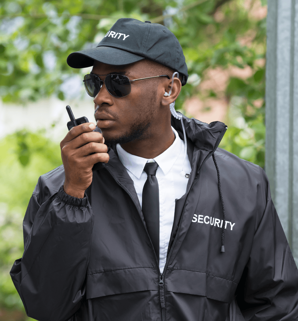 Security guard using walkie-talkie outdoors.