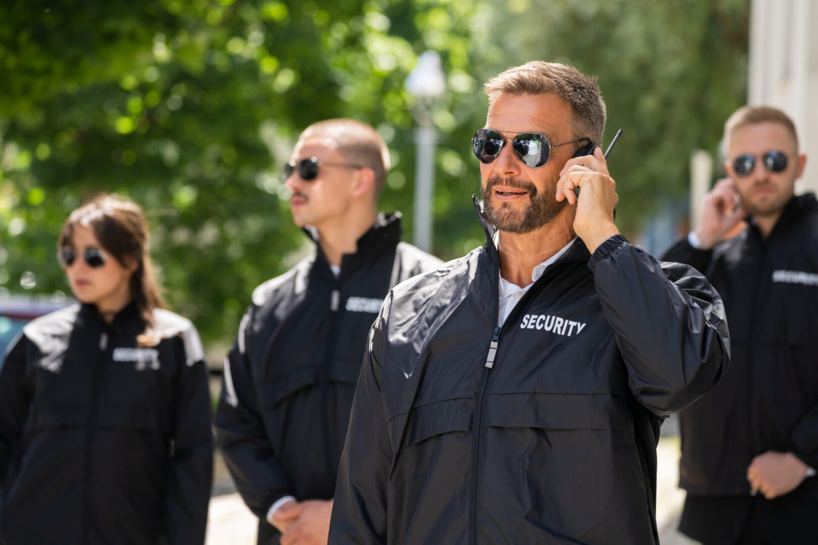 Security team in sunglasses with earpieces.