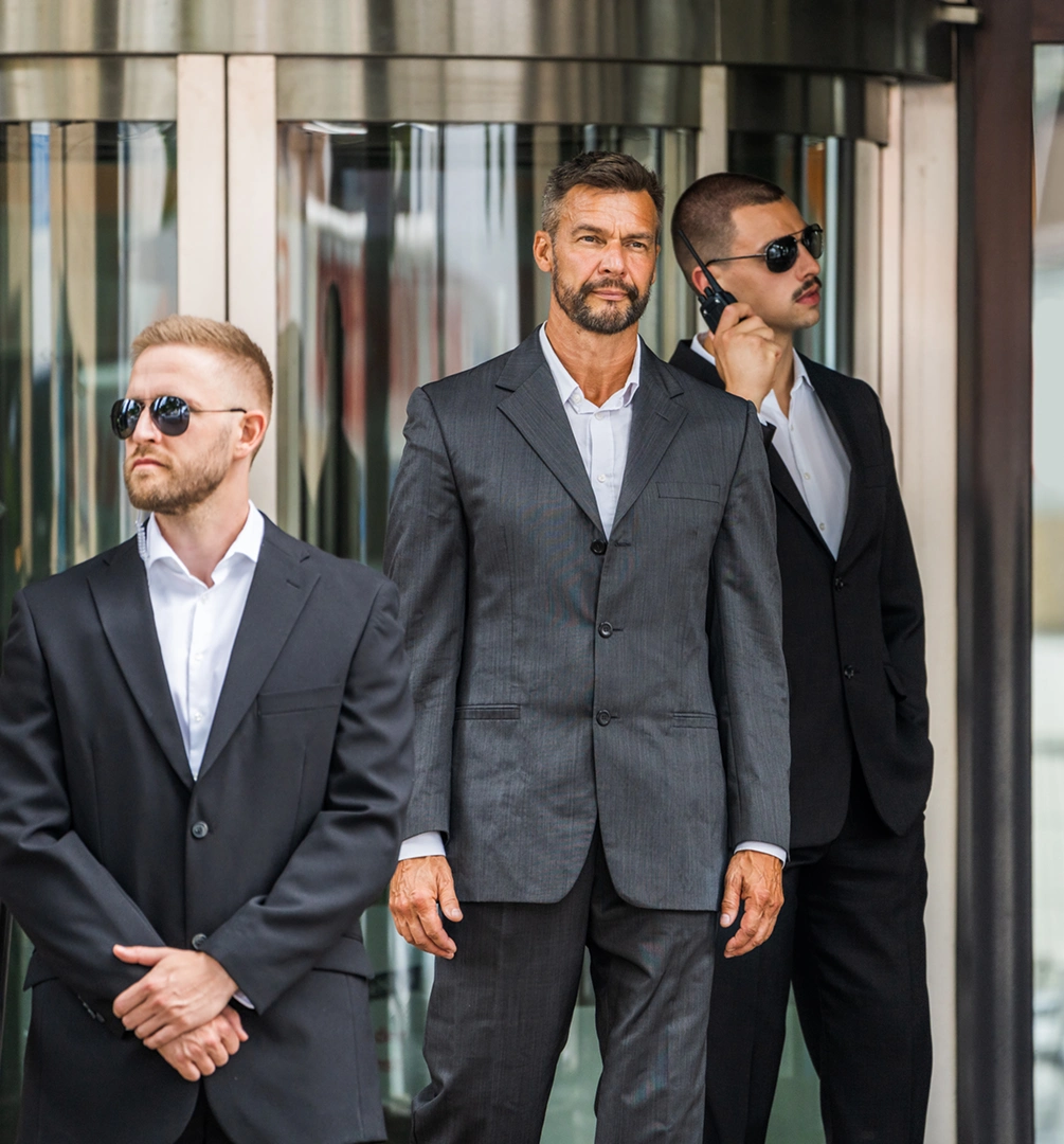 Three men in suits outside building entrance