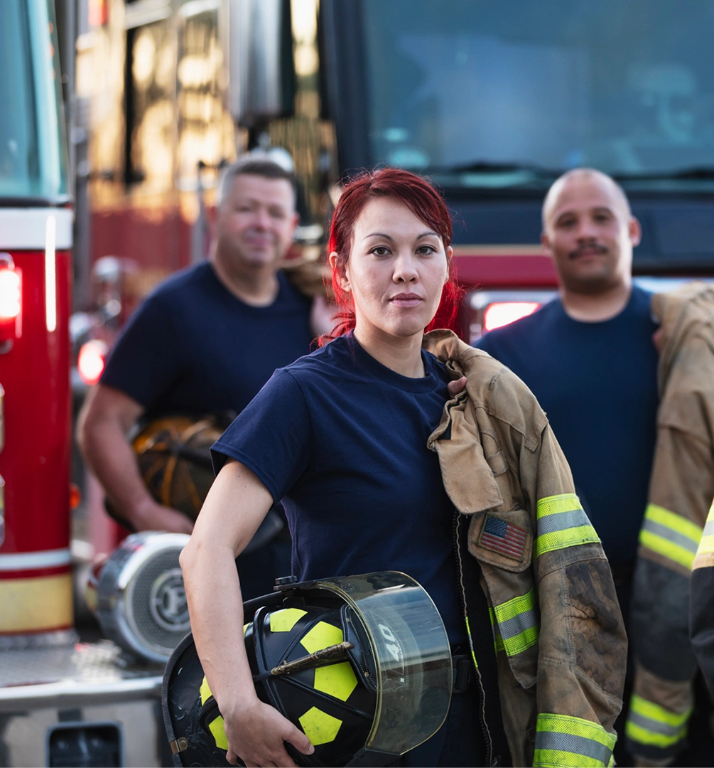 Firefighters standing by fire trucks