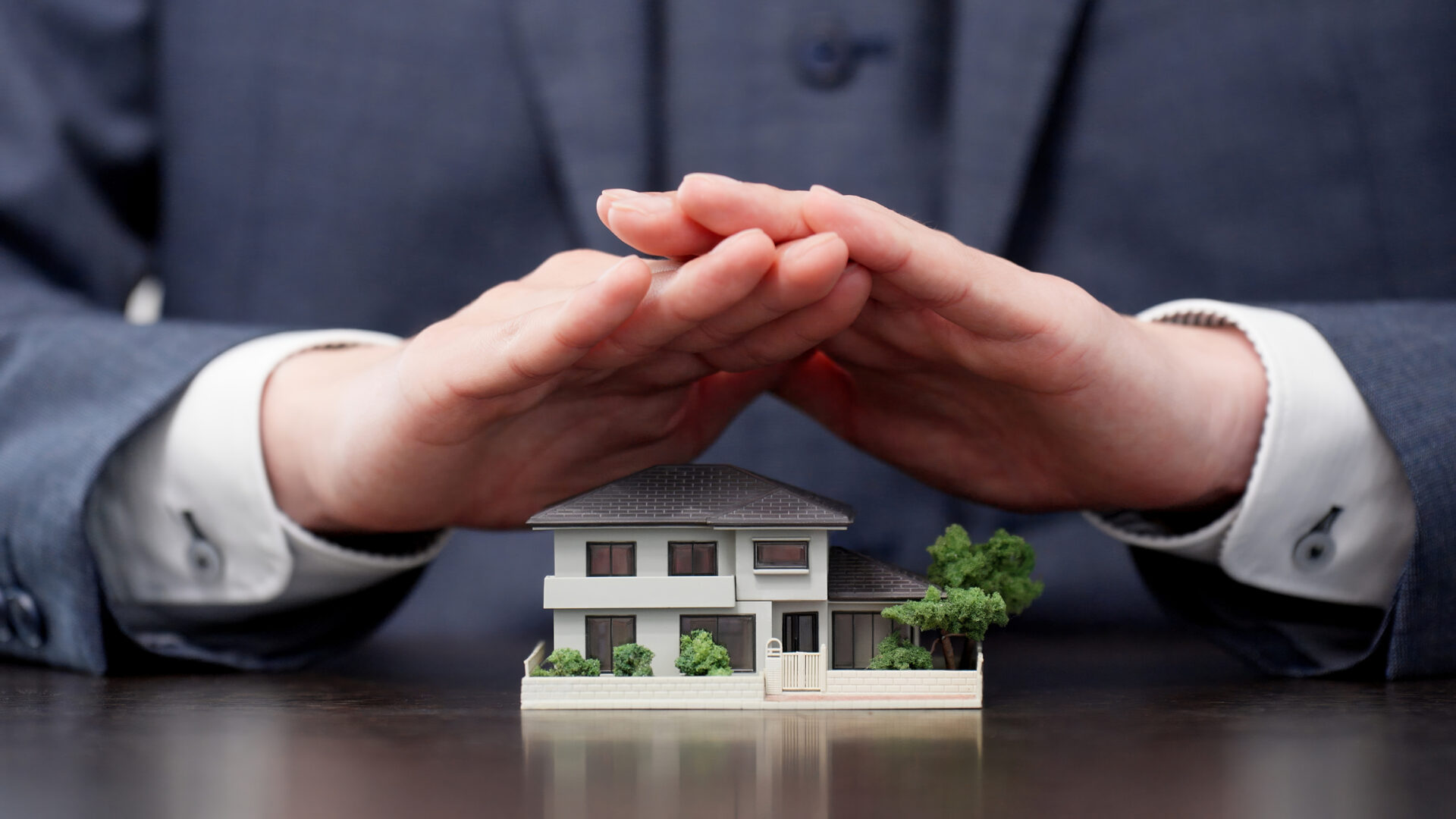 Model home under protective hands