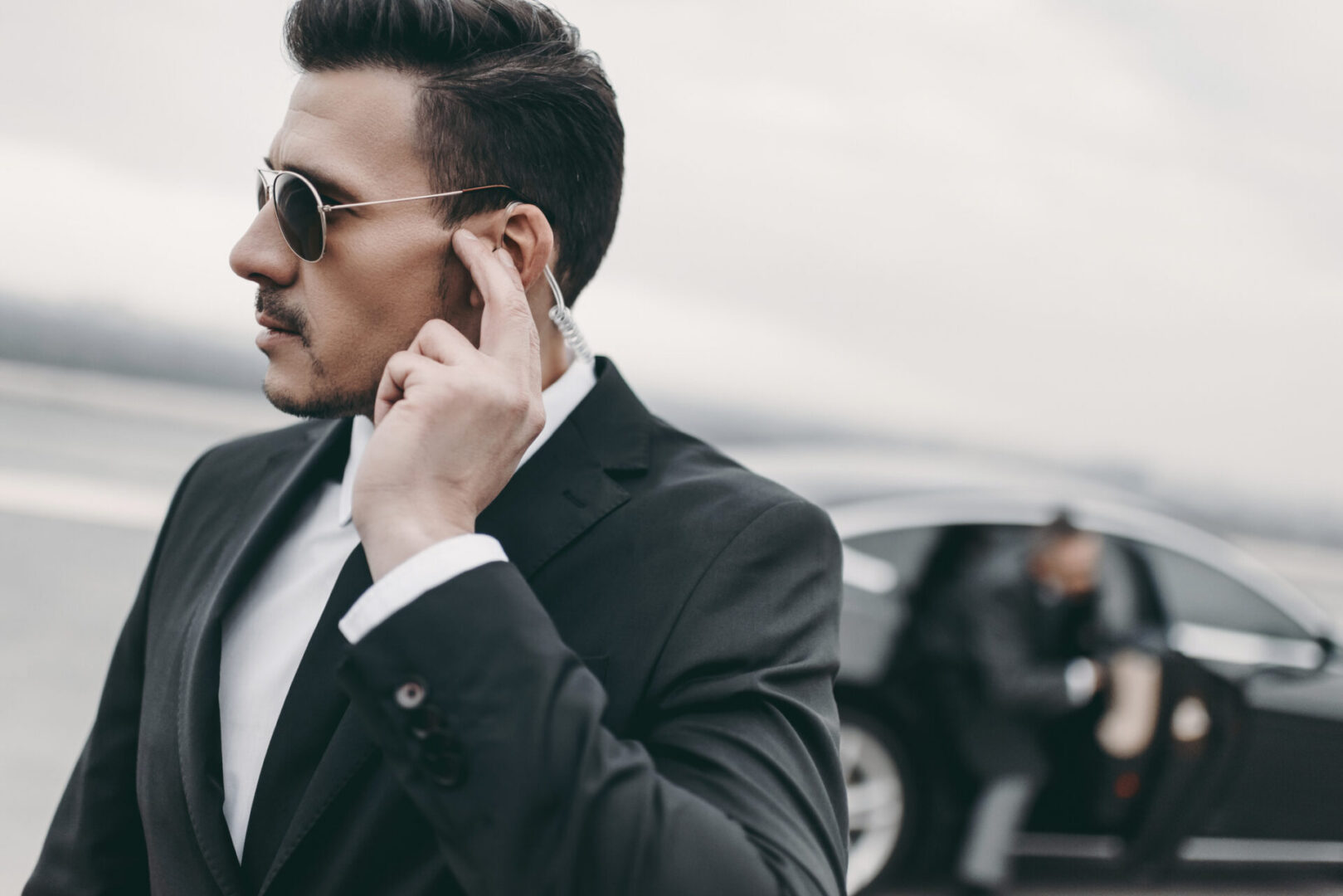 Security guard near a black car