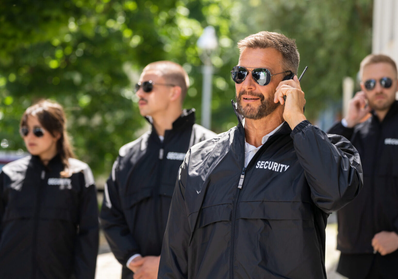 Security team in sunglasses with earpieces.