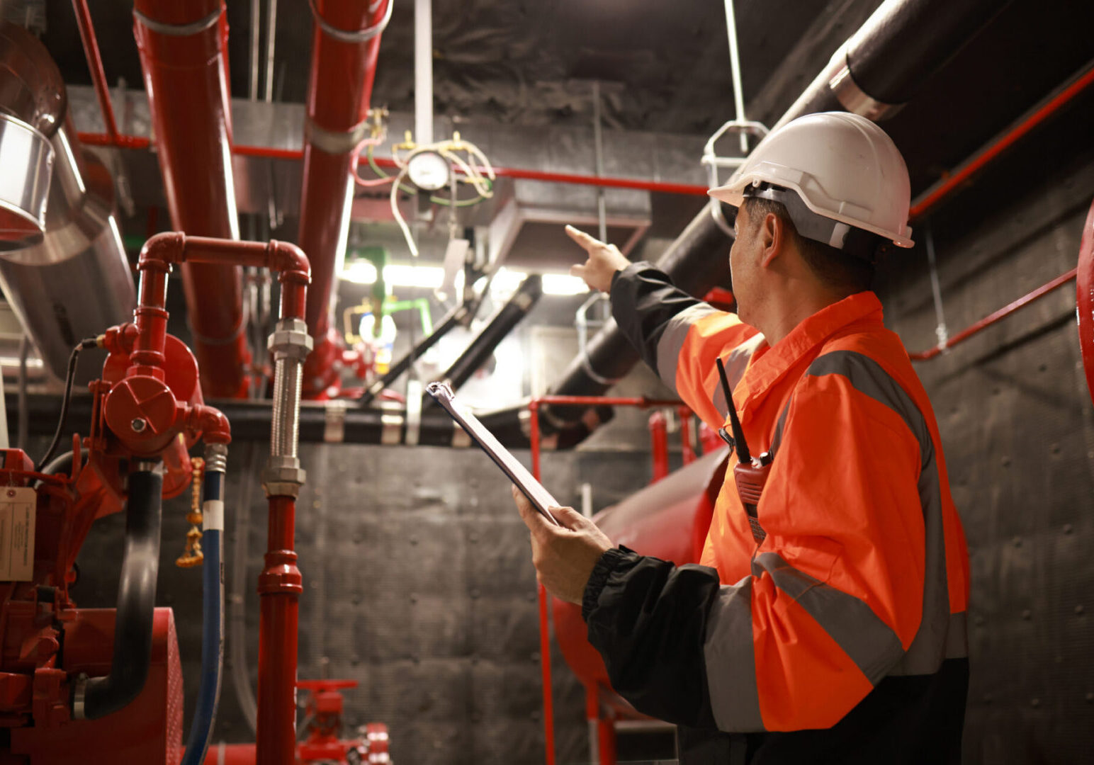 Technician pointing at factory pipework