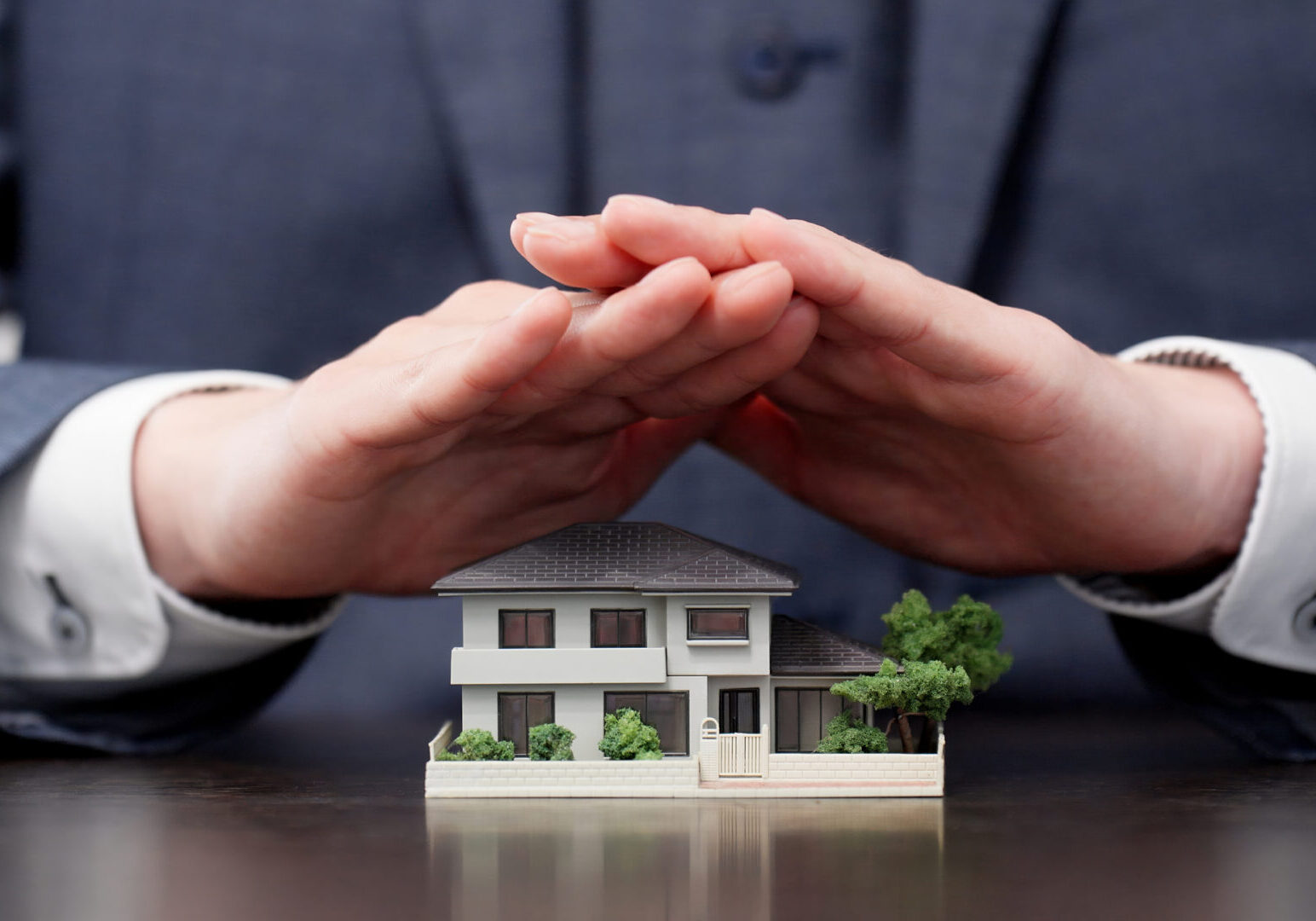 Model home under protective hands
