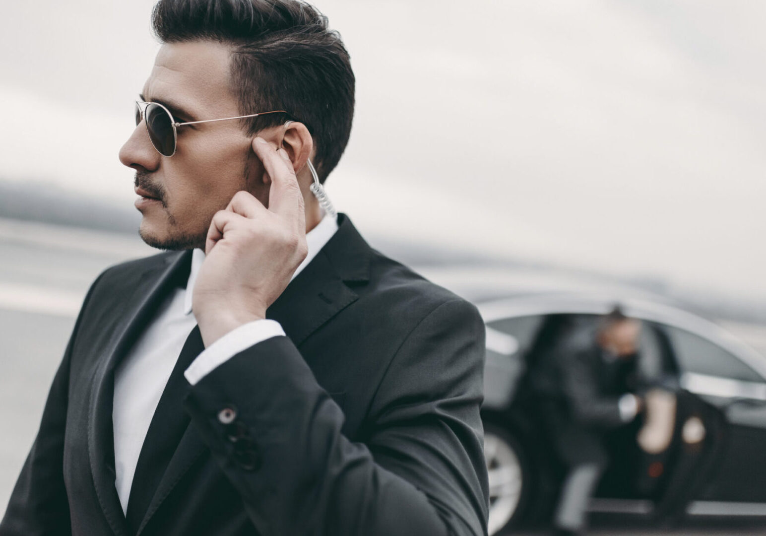 Security guard near a black car